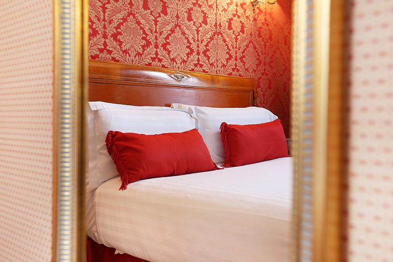 bed with red pillows in a mirror at the hotel de seine - easter weekend in Paris