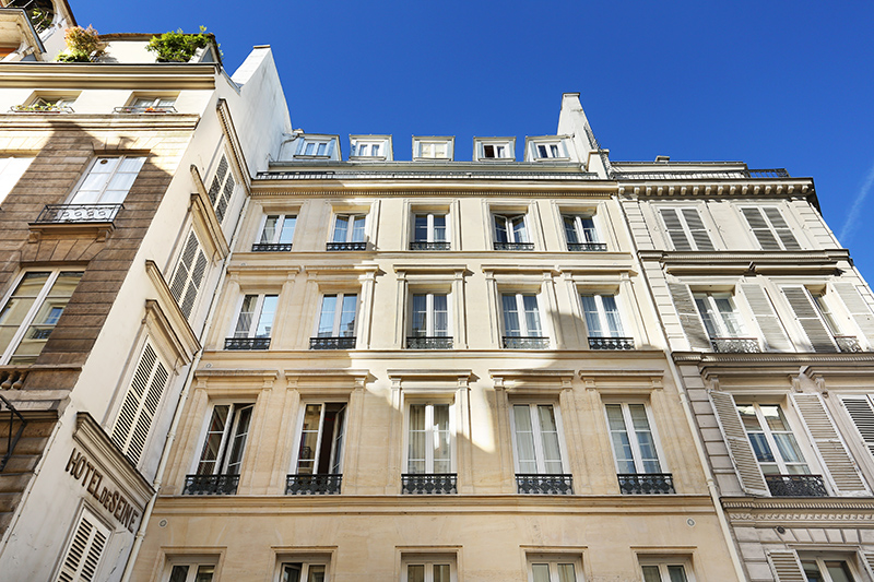 façade de l'Hôtel de Seine en pierre de taille sous un ciel bleu, jeux